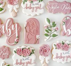 decorated cookies are arranged on a white surface with pink and green flowers in the center