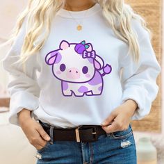 PLEASE NOTE: This is a adult UNISEX sweater. If you want an oversized look then consider ordering up a size. This cute plumberry cow sweater will look adorable on you! Makes for a great kawaii gift for your loved ones as well. The collar is ribbed knit, so it retains its shape even after washing. There are no itchy side seams on these sweaters. .: 50% cotton, 50% polyester .: Medium-heavy fabric (8.0 oz/yd² (271.25 g/m .: Loose fit .: Sewn-in label .: Runs true to size Cow Sweater, Kawaii Cow, Gifts For Teenage Girls, Boho Fashion Winter, Strawberry Cow, Positive Tees, Mama Sweater, Hoodie Streetwear, Crewneck Design