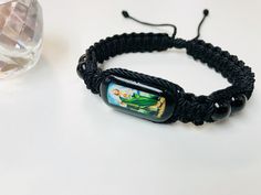 "Pulsera de San Judas Tadeo hecha a mano de doble tejido estilo Macrame con hilo reforzado en color negro. San Judas Tadeo el patrono de caso imposible. Pulsera ajustable y expandible para hombre o mujer con minimo cierre de 7\" pulgadas hasta maximo de 9\" pulgadas. Tableta de madera (1\"x 1/2\" x 1/4\" ) color verde obscuro con imagen de alta definicion San Judas en ambos lados y cubierta con resina Hilo reforzado #18 color Negro Bolas gemstone Onyx negro 8mm Nudo: 12" Black Woven Braided Bracelets For Gift, Black Woven Braided Bracelets As Gift, Black Woven Braided Bracelet For Gifts, Black Braided Bracelets As Gift, Black Woven Bracelet Gift, Handmade Black Braided Casual Bracelet, Handmade Black Casual Braided Bracelet, Casual Black Handmade Braided Bracelets, Casual Black Handmade Braided Bracelet