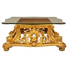 a glass and gold coffee table with an ornate design