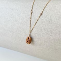 Handmade Honey Cowrie Shell Necklace with Handpicked Hawaiian Seashell and Freshwater Pearls on a 14k Gold Filled Chain.   Bring the beauty of the ocean to your everyday look with this handmade seashell necklace. Crafted with care, this unique piece features a Hawaiian seashell, found on Oahu, and Freshwater Pearls, set on a delicate 14k gold filled chain. The perfect accessory for beach lovers, mermaid souls, or anyone seeking a coastal vibe! Features: * Ethically Sourced Seashell: Cone Shell * Pearl: Freshwater * Chain Material: 14k Gold Filled * Chain Length: See Below * Lightweight and comfortable for daily wear * Handmade with Aloha Chain Length Options: * 16" (Fixed Length) * If you would like to have the option for the necklace to be adjustable, please make selection to "Add 2in Ext Cone Shell, Cowrie Shell Necklace, Seashell Necklace, Cowrie Shell, Shell Necklaces, Freshwater Pearls, Sea Shells, Gold Filled, Pearl Necklace