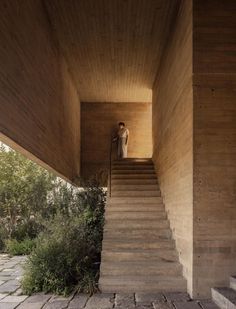 a woman is standing on the stairs in front of a wooden building with stone steps