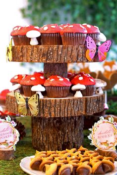 cupcakes and cookies are displayed on the table for guests to eat at this woodland themed birthday party