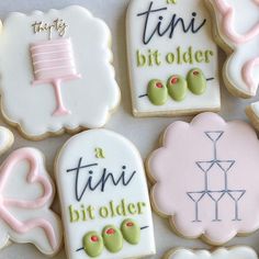 decorated cookies with different sayings on them sitting on a white tableclothed surface