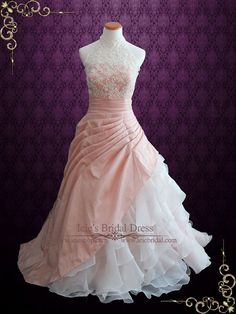 a pink and white wedding dress on display in front of a purple background with gold accents