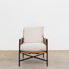 a chair that is sitting in the middle of an empty room with a white wall behind it