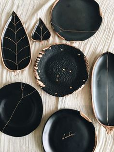 four black plates with leaf designs on them