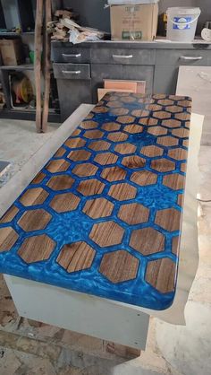 a table that has been painted with blue and brown designs on it, sitting in the middle of a kitchen