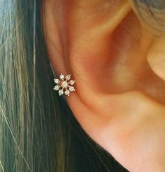 a close up of a person's ear with an earring on top of it