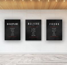 three black and white posters on the wall in an empty room with wood flooring