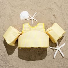 a yellow top and starfish on the beach