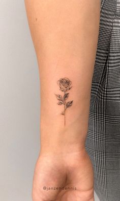 a woman's arm with a small rose tattoo on the left side of her wrist