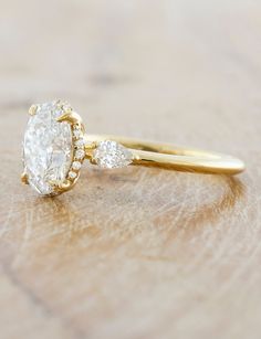 a close up of a diamond ring on a wooden surface