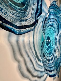 two blue and white glass vases sitting next to each other