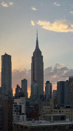 a city skyline with skyscrapers and clouds in the background