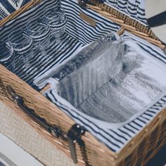 two wicker baskets filled with clothes on top of a white and blue striped rug