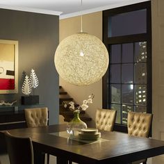 a dining room table with chairs and a chandelier hanging from it's ceiling