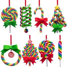 colorful lollipops are hanging from red and green ribboned christmas decorations with candy canes