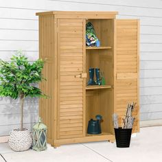 a wooden storage cabinet next to a potted plant