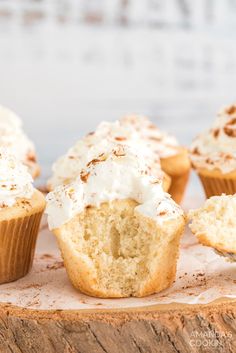 cupcakes with white frosting and cinnamon sprinkles on a wooden board