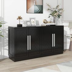 a black cabinet with two doors and some pictures on the wall next to a chair