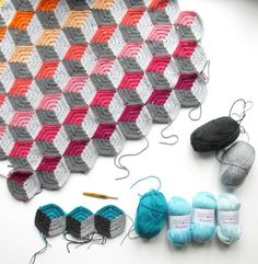 crochet and knitting supplies are laid out on a table with the yarns in different colors