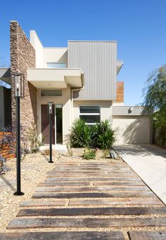 a modern house with stone steps leading to the front door