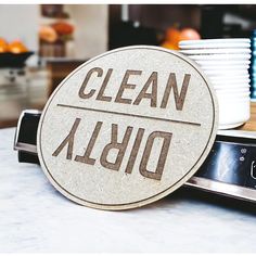 a close up of a cell phone on a table with plates and cups in the background