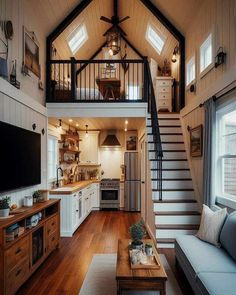 a living room and kitchen area in a small house with wood floors, white walls and ceilings