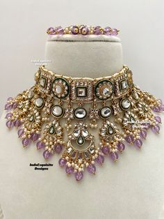 an elaborate necklace is displayed on a mannequins neckpiece with purple and white beads