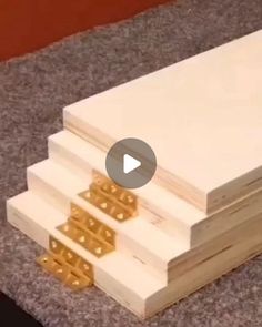 four pieces of wood stacked on top of each other with gold studs in them