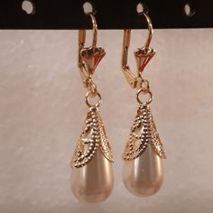 A nice edition to your jewelry set, this pair of earrings is larger than perceived, the droplet hangs low and makes a statement by the wearer. The laminated section holding the pearl has a design as well, this section glimmers once exposed to the sun. Details Laminated gold Pearl droplet design Elegant Gold Plated Teardrop Clip-on Earrings, Elegant Metal Dangle Drop Earrings, Elegant Metal Teardrop Earrings For Parties, Formal Drop Metal Earrings, Gold Clip-on Drop Jewelry, Teardrop Metal Clip-on Earrings For Gift, Drop Pearl Pendant Earrings, Elegant Gold-plated Teardrop Clip-on Earrings, Elegant Metal Drop Earrings