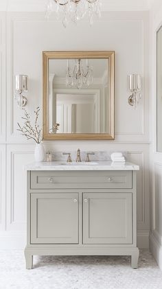 a bathroom vanity with a large mirror above it and chandelier hanging from the ceiling