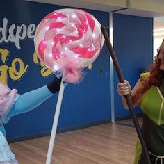 two women dressed in costumes are holding lollipops