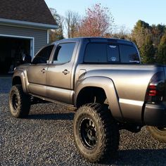 a silver truck parked in front of a garage