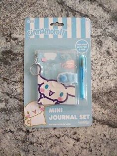 an animal shaped keychain with a blue pen in the front and a white cat on