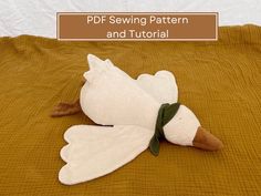 a stuffed bird laying on top of a bed with the words pdf sewing pattern and tutorial written above it