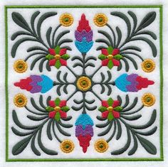 an embroidered square with colorful flowers and leaves on white fabric, in the center is a green border