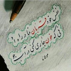 an arabic writing on a piece of paper with a pen in the foreground and another type of writing written below it