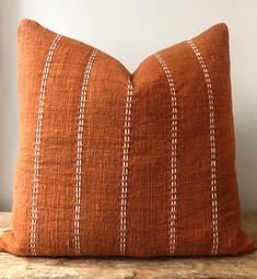 an orange pillow sitting on top of a wooden table