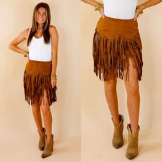 Model is wearing a caramel brown skirt with fringe in a zig zag pattern. Model has paired the skirt with a white bodysuit, brown booties, and gold tone jewelry. Suede Fringe Skirt, Tan Skirt, Giddy Up Glamour, Brown Skirt, Fringe Skirt, Suede Fringe, Zig Zag, Skirt Length, Turn Ons