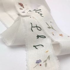 a white ribbon with embroidered words on it