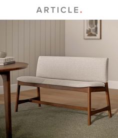 a wooden bench sitting on top of a carpeted floor next to a coffee table