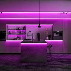 a kitchen with purple lighting in the ceiling and counter tops on either side of the island