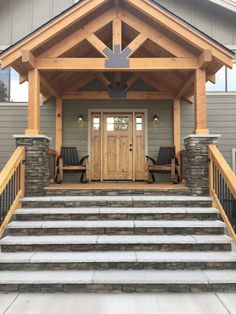 the front entrance to a home with stone steps and wooden railings on both sides