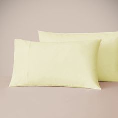 two yellow pillow cases sitting next to each other