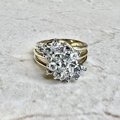 CLEARANCE - 40% OFF! A magnificent and fine vintage diamond cluster cocktail ring crafted in 14 karat yellow and white gold. Circa 1970. It is set with 19 round diamonds weighing approximately 1.35 CTTW.The stones are approximately G-H color, SI clarity. Stamped 14K. Weighs 8.5 grams. Size 6.75 US / N UK. > Ring sizing not included.This ring can be sized to fit most fingers.If you need to size this ring, please contact us before placing the order.Sized rings are final sale. Our minimum sizing fe Timeless Diamond Cluster Ring With 17 Jewels, Vintage White Cluster Ring With Rose Cut Diamonds, Diamond White Cluster Rings, Anniversary Diamond White Cluster Ring, Heirloom White Gold Cluster Diamond Ring, Heirloom White Diamond Cluster Ring, Vintage White Cluster Diamond Ring, Heirloom Cluster Diamond Ring In White Gold, Collectible Cluster Diamond Rings