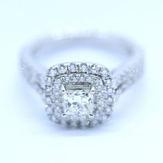 an engagement ring with a square cut diamond surrounded by small round diamonds