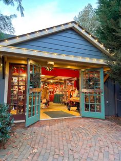 an open garage door with christmas lights on the roof and decorations hanging from it's sides