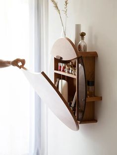 a person holding a paper in front of a shelf